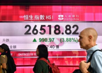 TIGA pengunjung melalui paparan saham Indeks Hang Seng, Hong Kong, semalam. Saham-saham di Asia Pasifk didagangkan lebih tinggi didorong oleh berita positif hubungan AS dan China. – GAMBAR HIASAN/AFP
