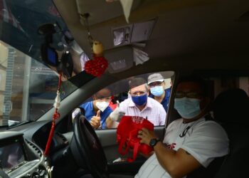 SAIFUDDIN Abdullah (tengah) membuat agihan 'mooncake' secara pandu lalu kepada masyarakat setempat di Pusat Khidmat Indera Mahkota, di Kuantan, Pahang. - UTUSAN/SHAIKH AHMAD RAZIF