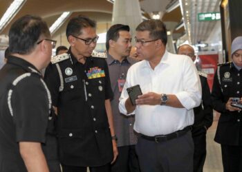 SAIFUDDIN Nasution Ismail berbual dengan Timbalan Ketua Pengarah (OperasiI) JIM, Jafri Embok Taha (dua kiri) ketika penghantaran pulang kanak-kanak lelaki warga Bangladesh di KLIA, Sepang, Selangor. - UTUSAN/FAISOL MUSTAFA