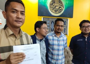 MOHD. Haffiz Mohd. Rasdin (kiri) menujukkan writ samannya terhadap Husam Musa semasa sidang media di Kota Bharu, Kelantan, semalam. - FOTO/YATIMIN ABDULLAH