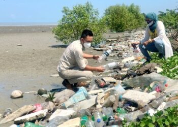 ROSNANI NAZRI dan Syamil Abd. Rahman meninjau sampah sarap yang memenuhi di pesisir Pantai Keria, Sungai Padang, Perlissemalam.- UTUSAN/MOHD. HAFIZ ABD. MUTALIB