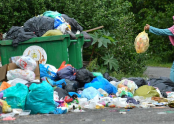 SEORANG penduduk membuang sampah di tong sampah yang penuh dan melimpah di Mengabang Lekor, Batu Rakit, Kuala Nerus, Terengganu. – UTUSAN/PUQTRA HAIRRY ROSLI