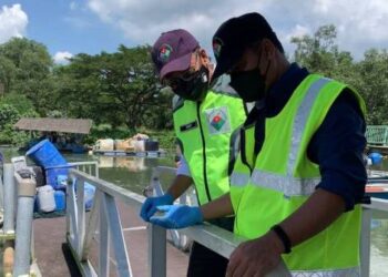 MOHD. Famey Yusoff (kiri) ketika melihat sampel yang diambil pegawai JAS di Jeti Nelayan Kampung Pasir Gudang Baru di Pasir Gudang, Johor.