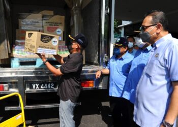 RONALD Kiandee (kiri) memasukkan produk makanan ke dalam lori sebelum dihantar ke Singapura untuk diberi kepada rakyat Malaysia sempena lawatan kerja bagi tinjauan Aktiviti Rantaian Pengeksportan Produk Pertanian Segar Malaysia ke Singapura di Pejabat FAMA, Johor Bahru, Johor. - UTUSAN/RAJA JAAFAR ALI