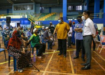 MUHAMMAD Sanusi Md. Nor (tengah) beramah mesra dengan penerima suntikan vaksin Covid-19 di PPV Daerah Kota Setar Stadium Sultan Abdul Halim, Suka Menanti, Alor Setar, hari ini. - UTUSAN/SHAHIR NOORDIN