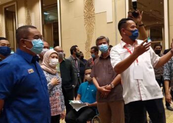 MUHAMMAD Sanusi Md. Nor (kiri) dan Nancy Shukri (dua kiri) diberi penerangan oleh Pegawai Kesihatan Daerah Langkawi, Dr. Mansor  Ismail  mengenai PPV Integrasi di LICC, Langkawi hari ini. - UTUSAN/NUR AMALINA AZMAN