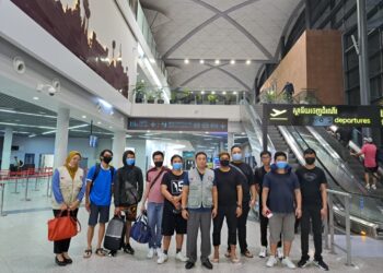 DUTA Besar Malaysia ke Kemboja, Datuk Eldeen Husaini Mohd. Hashim (tengah) bersama mangsa di Phnom Penh sebelum pulang ke tanah air. - IHSAN WISMA PUTRA