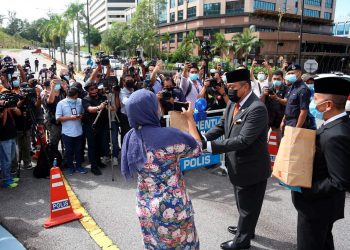 NAZIM Mohd. Alim menyampaikan bungkusan sarapan  kepada petugas media yang membuat liputan berita di luar pintu dua Istana Negara di Kuala Lumpur, hari ini. - Gambar Istana Negara