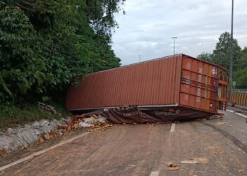 LORI kontena membawa muatan tin sardin terbabas dan melintang laluan di Kilometer 265.9, Lebuh Raya Utara-Selatan arah selatan dekat Kuala Kangsar, Perak, hari ini. - IHSAN JBPM PERAK