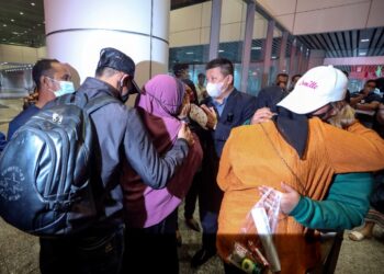 IBU mangsa memeluk anaknya yang menjadi mangsa sindiket jenayah penipuan tawaran pekerjaan di Bangkok, Thailand ketika tiba di KLIA, Sepang, Selangor. - UTUSAN/FAISOL MUSTAFA