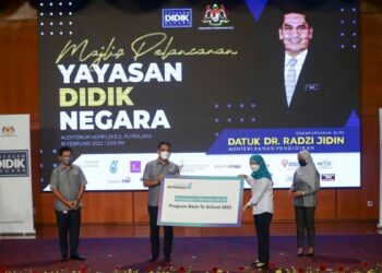 RADZI Jidin menerima replika cek bernilai RM10 juta daripada Ketua Pegawai Eksekutif Petronas, Shariah Nelly Francis (dua kanan) pada Majlis Pelancaran Yayasan Didik Negara di Auditorium Kompleks E, Putrajaya. - UTUSAN/FAISOL MUSTAFA