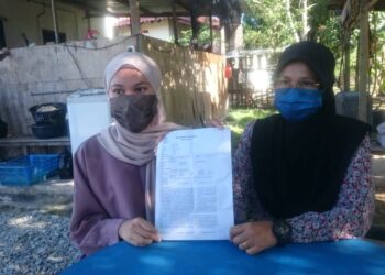 NURSYAFIQAH Badsulhisham (kiri) bersama ibunya, Zaharah Kassim yang juga Ketua Srikandi Bahagian Kota Tinggi menunjukkan salinan laporan polis yang dibuat terhadap Rasman Ithnain di Taman Guru, Kota Tinggi di Johor. -UTUSAN/MOHAMAD FAIZAL HASHIM