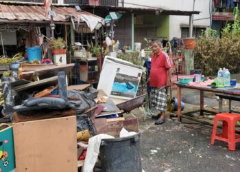 ROSLEN Abd. Razak mengemas rumahnya di Taman Sri Muda, Shah Alam yang dinaiki air baru-baru ini.