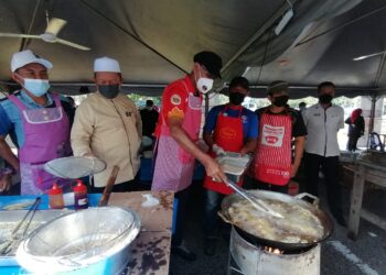 ROSOL Wahid (tiga dari kiri) menggoreng ikan semasa Program Jualan Keluarga Malaysia (PJKM) Parlimen Hulu Terengganu di Ajil, Hulu Terengganu hari ini. - UTUSAN/NOOR HAYATI MAMAT