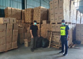ANGGOTA Pasukan Polis Marin menunjukkan bungkusan kotak mengandungi rokok yang dirampas di sebuah gudang di Taman Klang Jaya, Klang Khamis lalu.