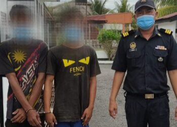 Pegawai KPDNHEP (kanan) membawa dua lelaki warga Thailand yang dipercayai menyeludup petrol dan diesel ke Mahkamah Majistret Machang, Kelantan. - IHSAN KPDNHEP