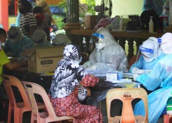 SEBAHAGIAN petugas hospital membuat ujian saringan Covid-19 ke atas penduduk Kampung Pauh Lima yang kini dikenakan PKPD di Surau Al-Ahmadiah, Bachok, Kelantan, semalam. - FOTO/ZULHANIFA SIDEK