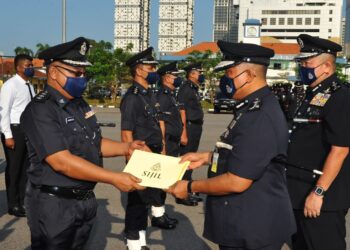 KAMARUL Zaman Mamat menyampaikan sijil penghargaan kepada salah seorang anggota polis sempena Sambutan Hari Polis ke 215 di Padang Kawad IPK, Johor Bahru. - UTUSAN/RAJA JAAFAR ALI