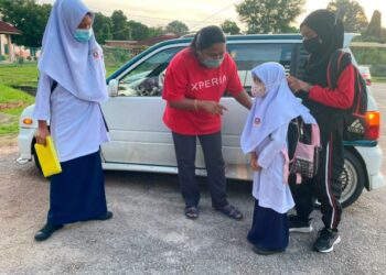 NORZILA Ahmad Din ketika menghantar anak-anaknya ke SK Tanjung Minyak, Paya Rumput, Melaka. - UTUSAN/DIYANATUL ATIQAH ZAKARYA
