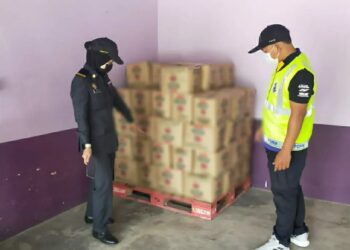 ANGGOTA KPDNHEP Kelantan bersama PPM Wilayah Tiga Pengkalan Kubor memeriksa barangan kawalan yang dirampas dalam serbuan di Kampung Bukit Merah Dalam, Tanah Merah, Kelantan semalam.  -IHSAN KPDNHEP Kelantan