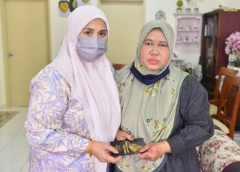 ENGKU NOORASIKIR Engku Lah (kiri) menyampaikan sumbangan kepada Azimiyah Yaakob di kediamannya di Kuantan, Pahang. - UTUSAN/SHAIKH AHMAD RAZIF
