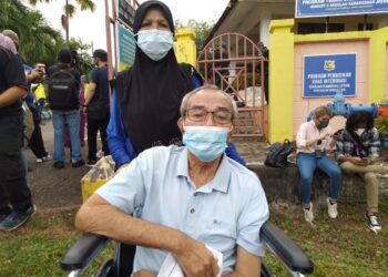 BAHARI Siron bersama Rasnah Simpon selesai membuang undi di pusat mengundi SK Jeram di Masjid Tanah, Melaka. - UTUSAN/MUHAMMAD SHAHIZAM TAZALI