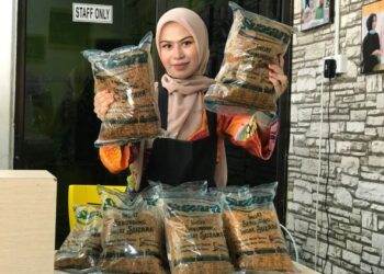 FATIN Nabila Sukri menunjukkan Serunding Suzara yang dikeluarkan di kilang di Kampung Laut, Tumpat. - UTUSAN/ROSLIZA MOHAMED