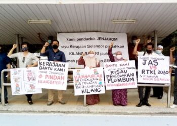 MOHD. Nazri Afrizal (tiga dari kiri) bersama penduduk Kampung Jenjarom mengangkat sepanduk membantah pembukaan semula kilang buat bateri berdekatan kediaman mereka di Bangunan SUK, Shah Alam, Selangor, hari ini. - FOTO/MOHAMAD NAUFAL MOHAMAD IDRIS