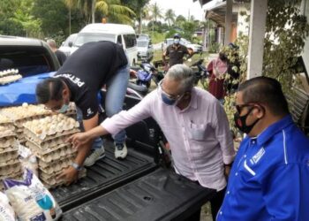 NOH Omar (tengah) menyerahkan bekalan telur ayam di sebuah rumah di Kampung Bestari Jaya, Kuala Selangor untuk diagihkan kepada 61 keluarga di kampung berkenaan. - UTUSAN / MOHAMAD ATHIR ISMAIL