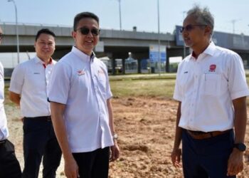 TENG Chang Khim (tengah) dan Azmir Merican (kanan) bergambar berlatarbelakangkan persimpangan bertingkat di Jalan Meru yang menghubungkan Persiaran Sungai Keramat, Persiaran Astana dan Bandar Setia Alam di Klang, Selangor, hari ini. - FOTO/ZULFADHLI ZAKI