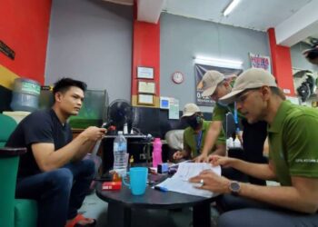 MOHAMMED Azman Aziz Mohammed memeriksa seorang pekerja dekat sebuah kedai cuci kereta dalam Op Kesan Perkeso untuk memastikan majikan mendaftar dan mencarum untuk pekerja mereka di Shah Alam, Selangor, hari ini.