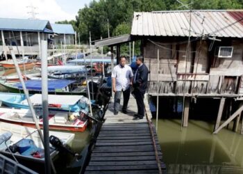 SHAHMAN Jalaludin (kanan) meninjau kesan akibat fenomena air laut pasang besar di Jeti Nelayan Kampung Tok Muda di Klang, Selangor, semalam. - FOTO/MOHAMAD NAUFAL MOHAMAD IDRIS