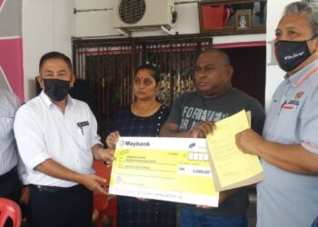 ZAINOL Abu (dua dari kiri) menyerahkan Faedah Pengurusan Mayat kepada keluarga mendiang E. Darwin Liew dekat Taman Paduka di Kuala Selangor, Selangor, hari ini.