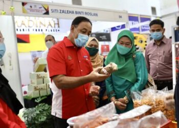 MOHAMAD Yasid Bidin (tengah) memerhatikan produk jualan pengusaha Kemas selepas merasmikan Program ‘Riooh Raya Is Back’ di Pusat Beli Belah GM Klang, Selangor, hari ini. - FOTO/ZULFADHLI ZAKI