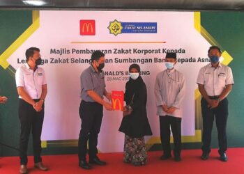 MUHD. Fikri Naim (kiri) menyaksikan program sumbangan kepada asnaf mangsa banjir oleh McDonald’s Malaysia di Banting, Kuala Langat, Selangor, hari ini. - FOTO/ABDUL RAZAK IDRIS