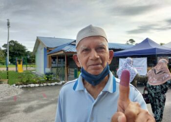 SHAHBUDIN Isa menunjukkan jari yang dicelup dakwat biru selepas melaksanakan tanggungjawab sebagai pengundi di SK Sungai Bayor, Rantau Panjang, Selama di Larut, Perak. - UTUSAN