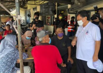 MOHD. Shafie Apdal (kanan) menyantuni masyarakat di sebuah restoran selepas sidang akhbar di Kluang, Johor.