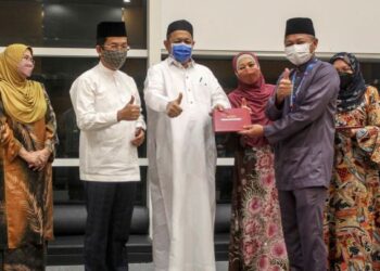SHAHIDAN Kassim (tengah) menyampaikan sijil penghargaan sukarelawan misi bantuan banjir KWP kepada Naib Presiden Kanan Perbadanan Putrajaya, Datuk Fadlun Mak Ujud (dua kanan) di Putrajaya. - UTUSAN/FAISOL MUSTAFA