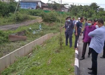 MOHD. Sharkar Shamsudin (kanan) meninjau kesan banjir kilat di Taman Mentakab Indah, Pahang, semalam.