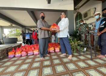 SHAUKI Abd. Majid (kanan) menyampaikan  sumbangan zakat ahli korporat kepada Surial Saat untuk diagihkan kepada asnaf di Masjid Tok Imam Long, Cherang Ruku, Pasir Puteh, hari ini. - UTUSAN/TOREK SULONG