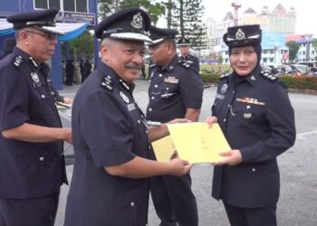 WAN Rukman Wan Hassan (kiri) menyerahkan sijil penghargaan kepada salah seorang anggota pada Majlis Perbarisan Sempena Hari Polis Ke-216 di Kuala Terengganu, hari ini. 