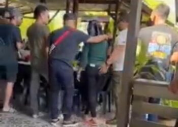 TANGKAP  layar rakaman klip video memaparkan dua pelanggan lelaki memeluk bahu dan pinggang seorang wanita di sebuah kedai makan yang tular dalam media sosial sejak kelmarin. - MEDIA SOSIAL