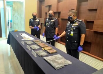 KAMARUL Zaman Mamat (kanan) menunjukkan sebahagian daripada dadah yang dirampas di IPK Kedah di Alor Setar, Kedah. - UTUSAN/MOHD. RAFIE AZIMI 