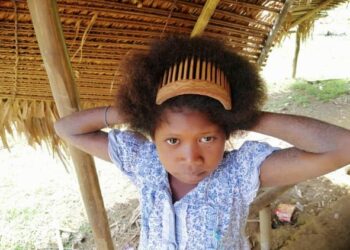 SEORANG kanak-kanak Orang Asli etnik Bateq memakai sikat dan menjadikannya sebagai penyepit supaya dandanan rambut kelihatan kemas dan menarik di Kampung Bengoi, Hulu Tembeling di Jerantut, Pahang. - FOTO/HARIS FADILAH AHMAD