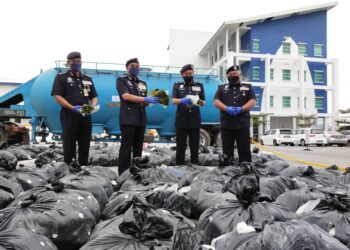 SHAFIEN Mamat (dua kiri) bersama pegawai lain menunjukkan bungkusan berisi daun ketum yang dirampas dari lori tangki simen di SJR Chetok, Pasir Mas, Kelantan hari ini. - UTUSAN/YATIMIN ABDULLAH