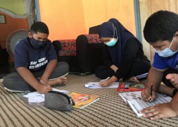 SUFIYYAH Qurratuain Sulaiman mengikuti kelas secara dalam talian di pintu dapur rumahnya bagi mendapatkan capaian internet di Kampung Pondok Lama, Pokok Sena, Alor Setar.  - UTUSAN/NUR ANATI JUHARI