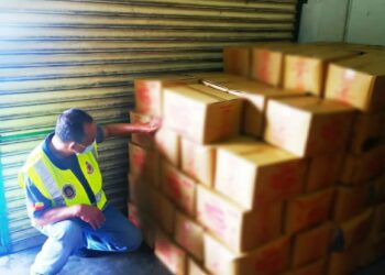 ANGGOTA KPDNHEP Kelantan memeriksa minyak peket bersubsidi yang disorokkan dalam serbuan di Kok Lanas, Kelantan, semalam. -IHSAN KPDNHEP KELANTAN