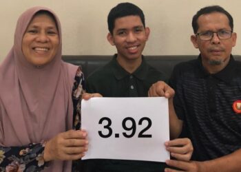 MUJAHID Abdullah (tengah) bergambar bersama ibu bapanya di Pokok Sena Kedah.-UTUSAN/ABDUL RAZAK IDRIS