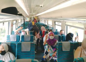 SEBAHAGIAN penduduk memenuhi ruang gerabak tren percuma DMU Keretapi Tanah Melayu Berhad yang singgah di Stesen Keretapi Mela di Lipis, Pahang. - UTUSAN/HARIS FADILAH AHMAD