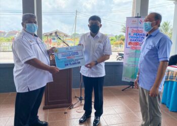 MOHD. Izhar Ahmad (tengah) menyampaikan simbolik dana Program Jualan Koperasi Prihatin Rakyat (JKPR) kepada penerima di SMK Senggarang Batu Pahat di Johor -UTUSAN/NUR ALINA HASSAN